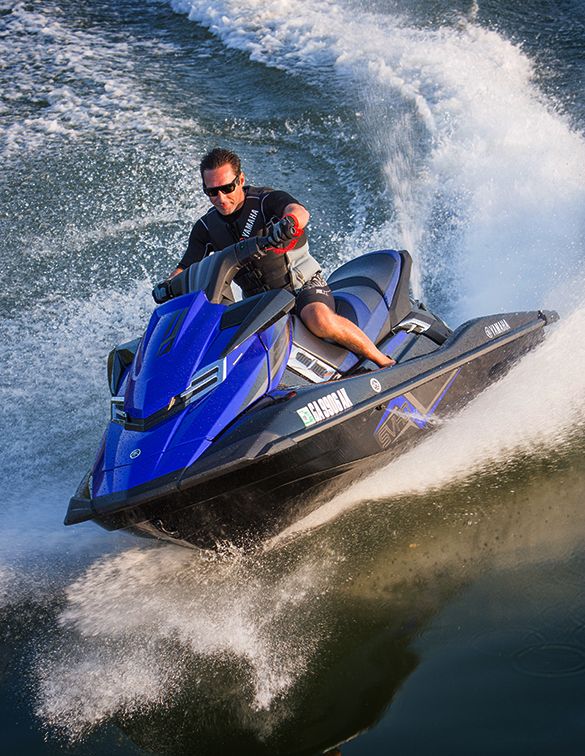 a man riding on the back of a blue and black jet ski