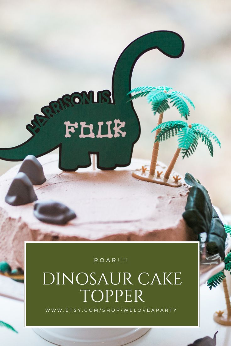 dinosaur cake topper with palm trees and rocks