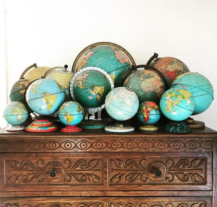 an old dresser with many globes on it