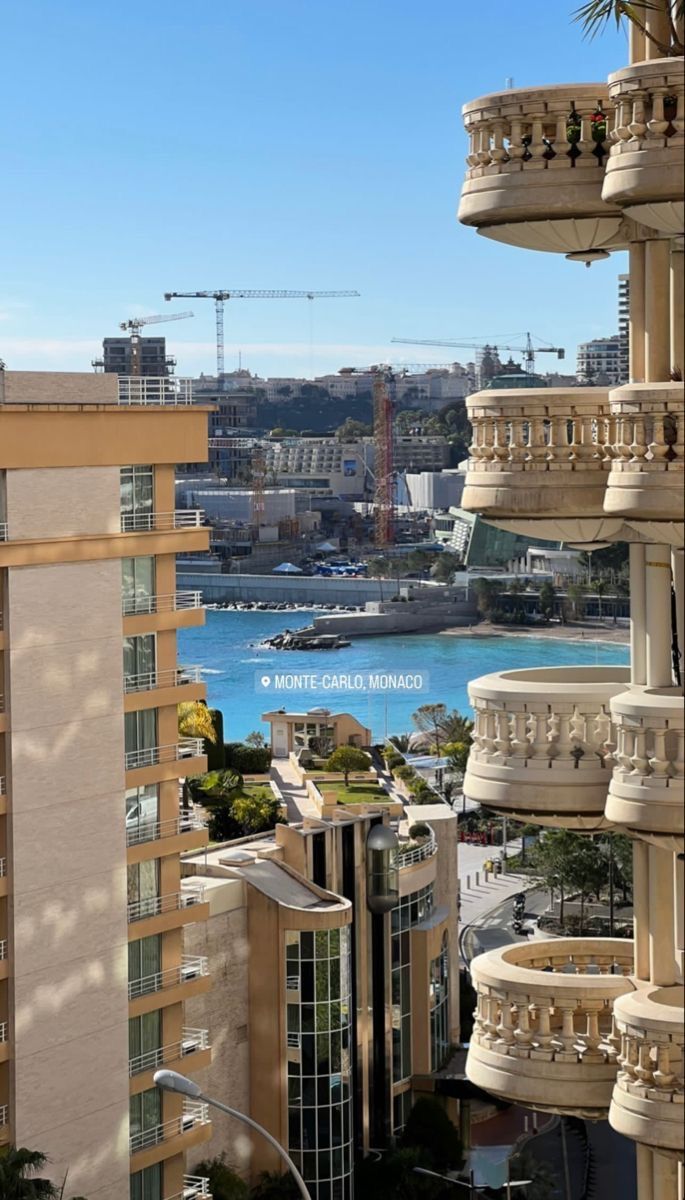 an apartment building with balconies overlooking the water and cityscape in the background