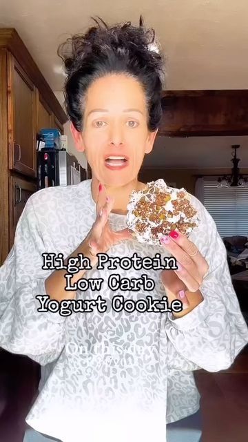 a woman holding a doughnut in her hands with the caption high protein low carb yogurt cookie