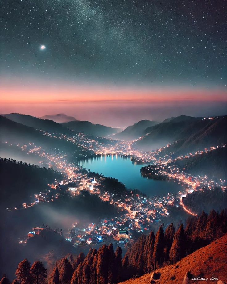 the night sky is filled with stars and lights above a town on a mountain top