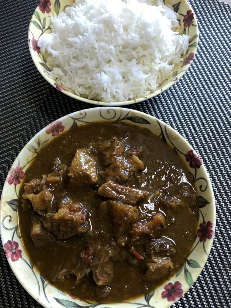 two bowls filled with rice and meat on top of a table