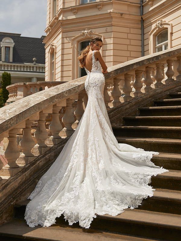 a woman in a wedding dress standing on some stairs