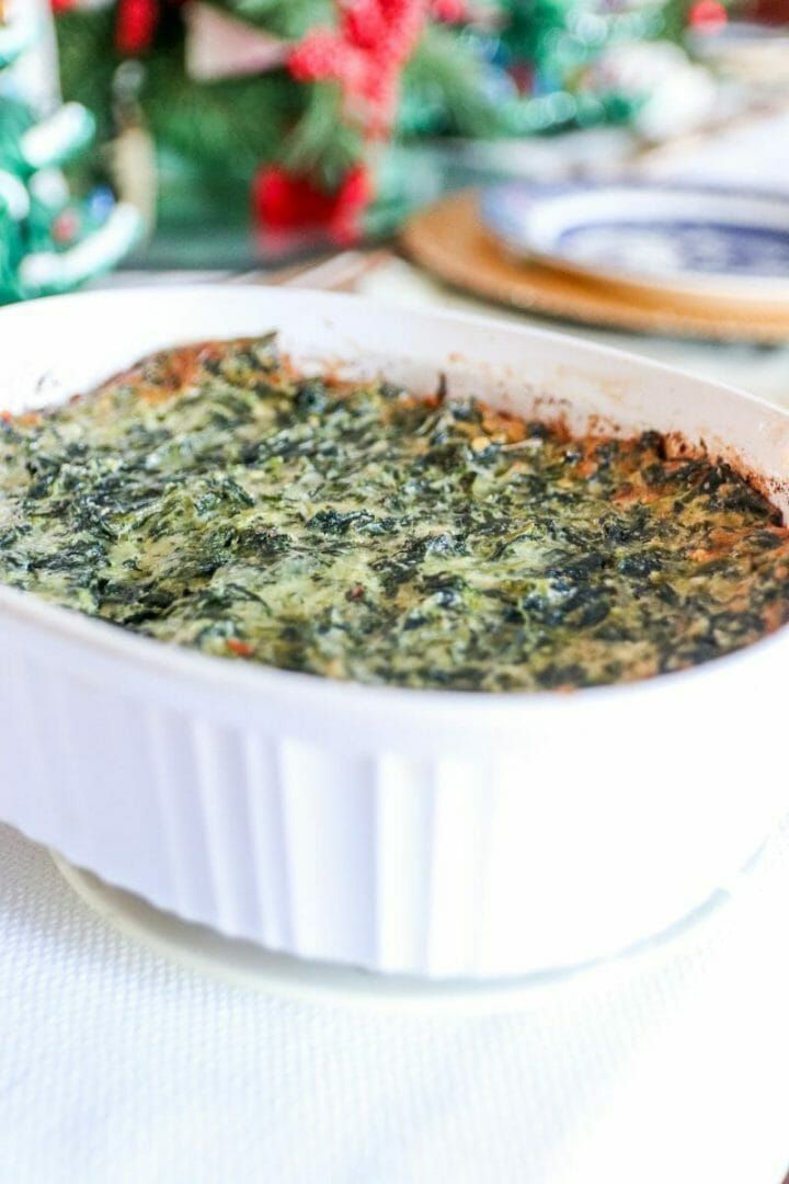 a casserole dish with spinach and cheese in it sitting on a table