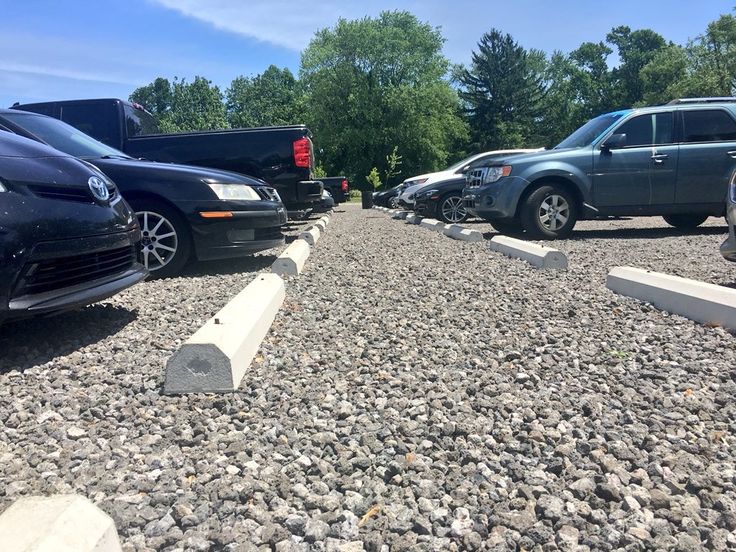 several cars are parked on the side of a road with rocks in front of them