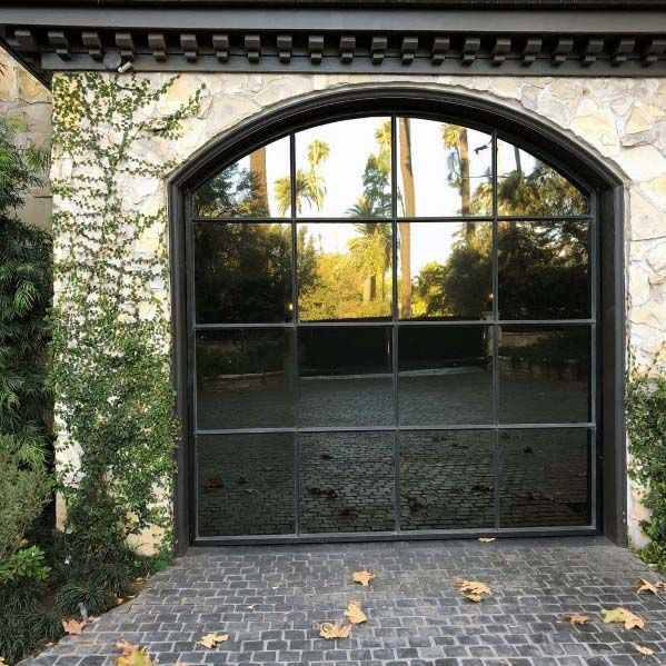 an open garage door in front of a stone building with ivy growing on the outside