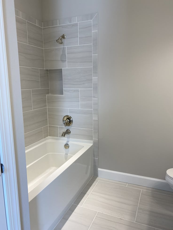 a bathroom with a white toilet and bathtub next to a walk - in shower