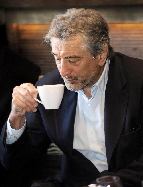 black and white photograph of a man holding a coffee cup