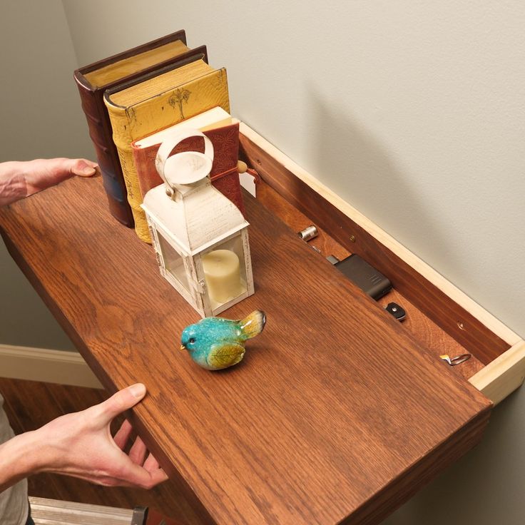 two hands reaching for an object on top of a table with books and other items