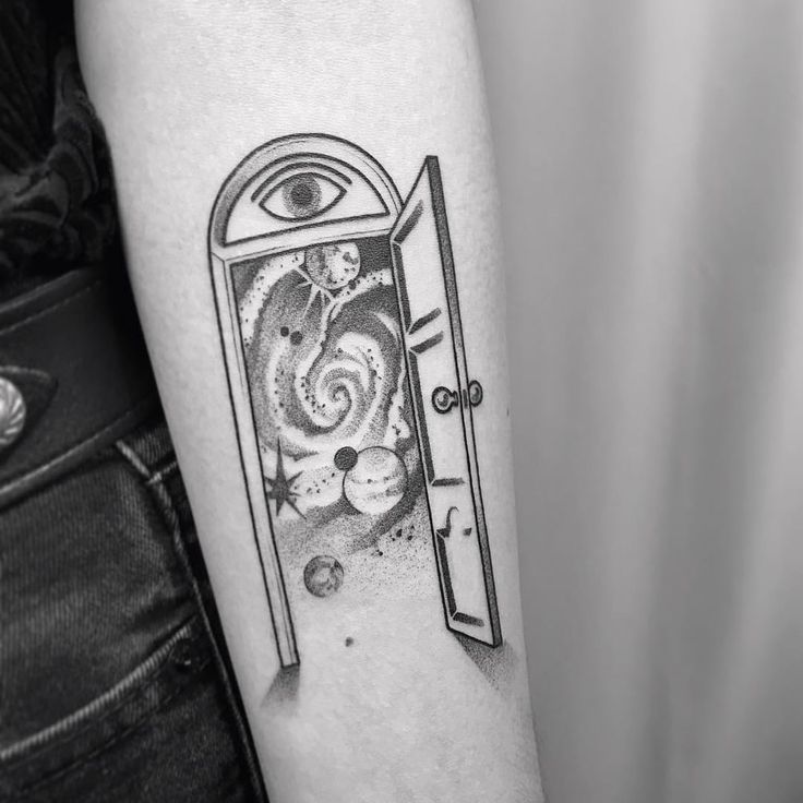 a black and white photo of an open door to another world tattoo on the arm