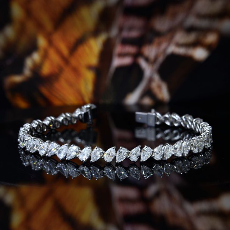 This 9.00 carat brilliant pear cut diamond tennis bracelet have a remarkable 100% eye-clean VS2 clarity grading and G color grading (very white) where these diamond stones glitters and sparkles perfectly. It is a magnificent prong setting that stretches to 7.5 inches long (other length available by request). Metal : 14K Gold or 18K Gold Setting Type : Prong Total Carat Weight : 9.00 Carats Type : Natural Shape : Pear Cut Carat Weight : 9.00 Ct. Cut : Excellent Color : G (White) Clarity : VS2 (10 Pear Shaped Tennis Bracelet, Pear Shape Diamond Bracelet, Unique Gold Jewelry Designs, Bracelet Diamond, Diamond Jewelry Necklace, Pear Cut Diamond, Diamond Tennis Bracelet, Color Grading, Diamond Bangle