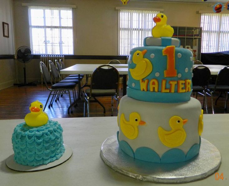 there are two cakes with rubber ducks on the top one is blue and the other is yellow