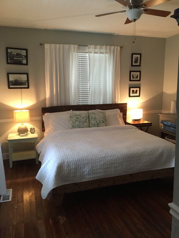 a bed sitting in a bedroom next to two lamps on either side of the bed