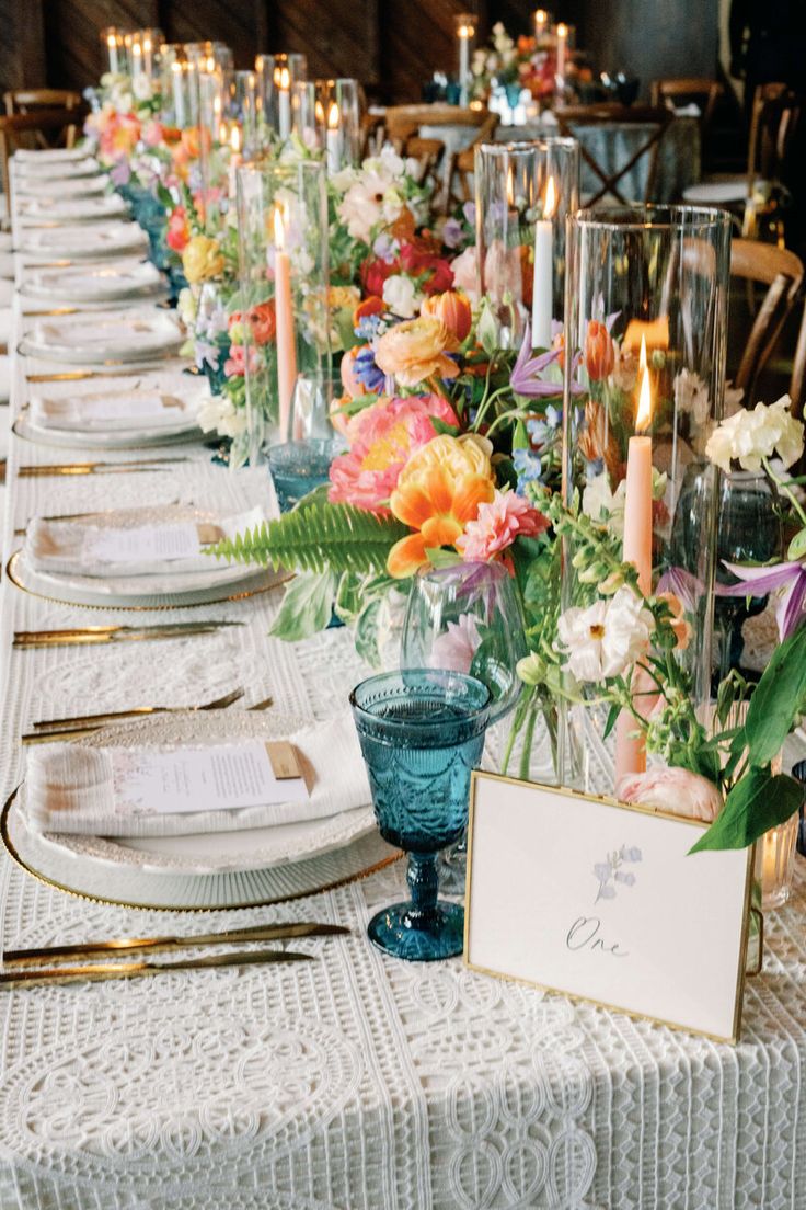 a long table is set with flowers and candles