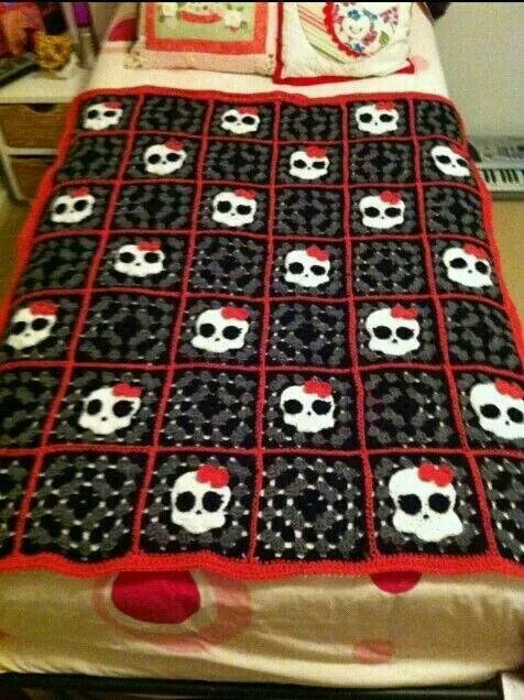 a bed with a skull quilt on top of it