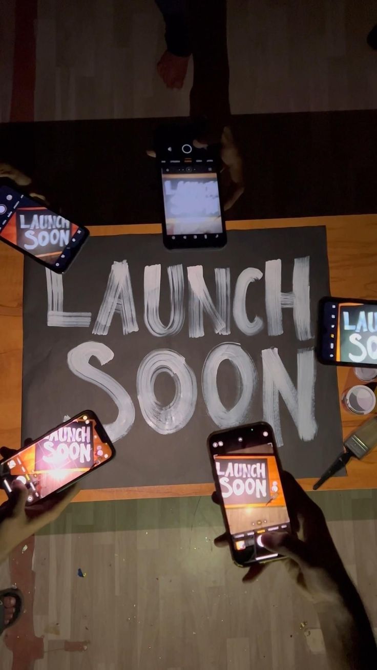 several people holding their cell phones in front of a sign with the words launch soon written on it