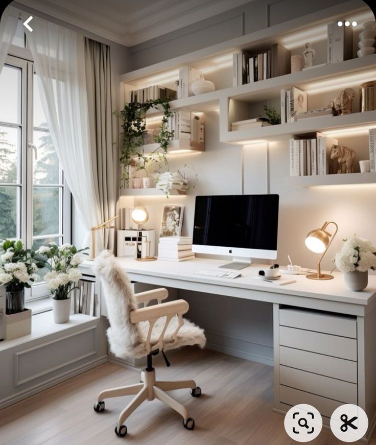 a white desk with a computer on top of it in front of a large window