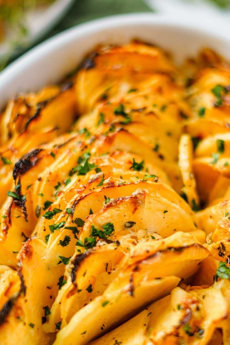 a white bowl filled with pasta covered in parmesan cheese and garnished with herbs