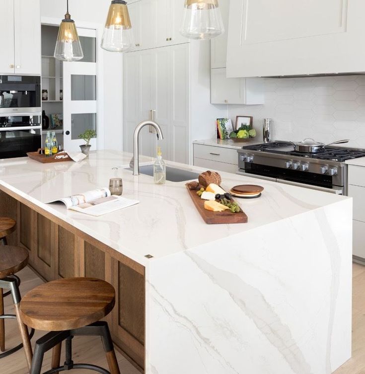 a kitchen with marble counter tops and wooden stools