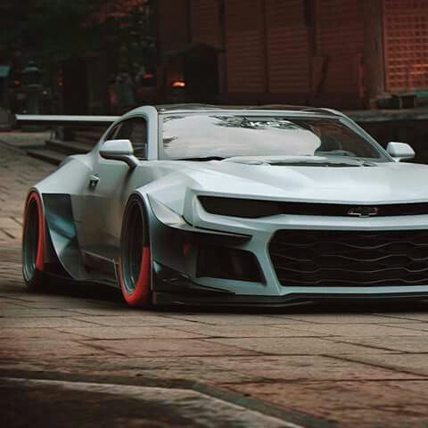 a white sports car parked in front of a building