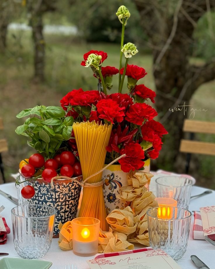 a table topped with lots of different types of food and flowers on top of it