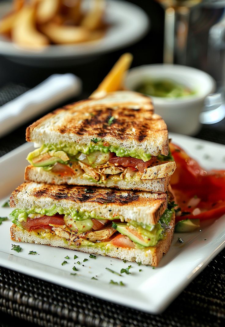 two grilled sandwiches are stacked on a plate