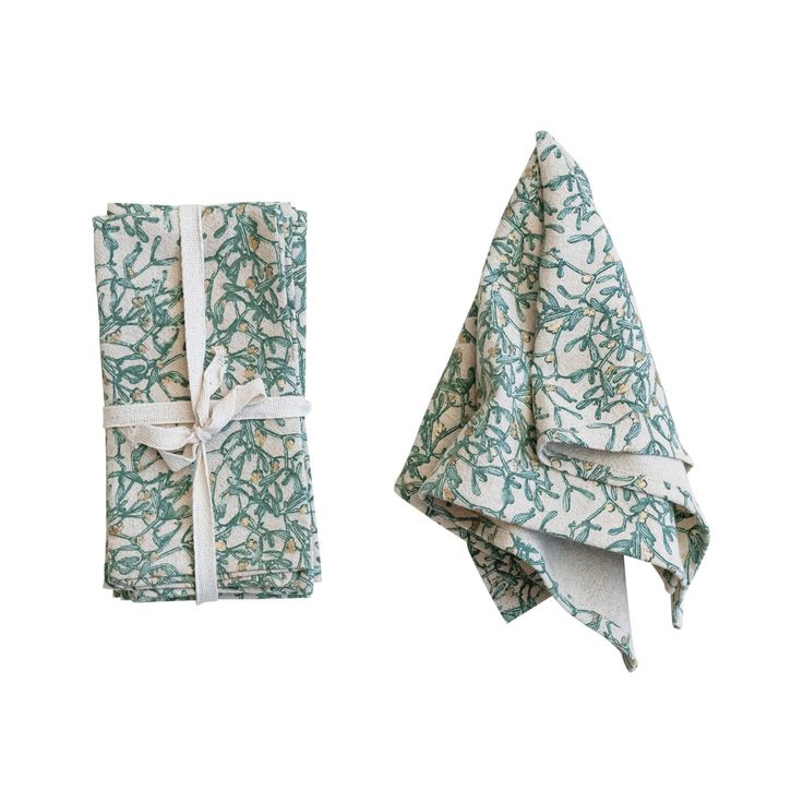 two towels are folded on top of each other, one has a green and white design