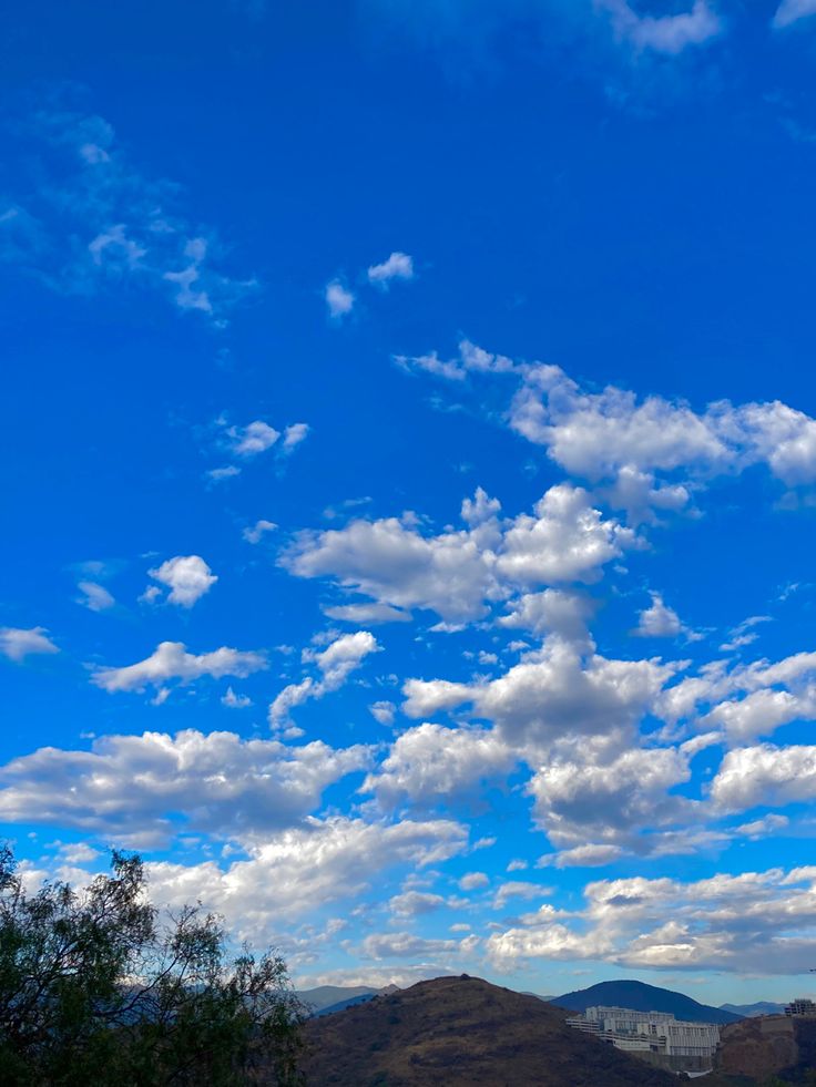 the sky is filled with white clouds and blue skies