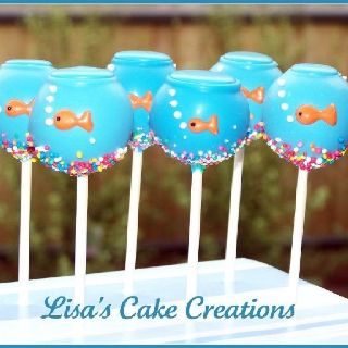 four blue vases with fish on them sitting on top of a cake popsicle