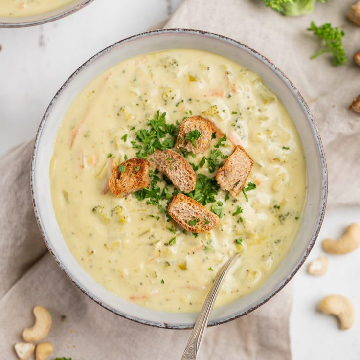 two bowls filled with soup and topped with croutons