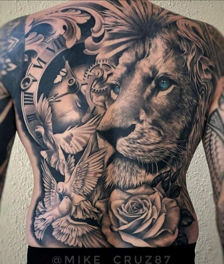 a man's back with tattoos on his body and an image of a lion