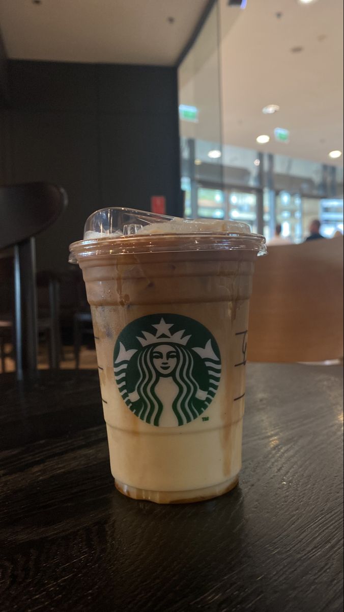 a starbucks drink sitting on top of a wooden table