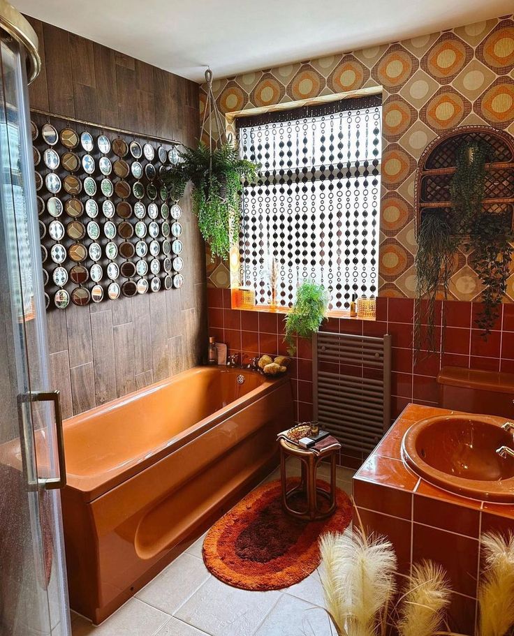 an orange bath tub sitting next to a window in a bathroom with tile walls and flooring