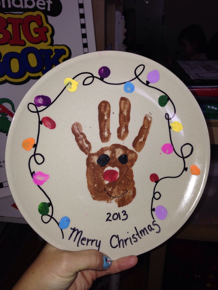 a paper plate with a handprinted christmas ornament on the front and bottom