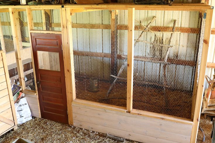 the inside of a chicken coop with hay on the floor and other things in it