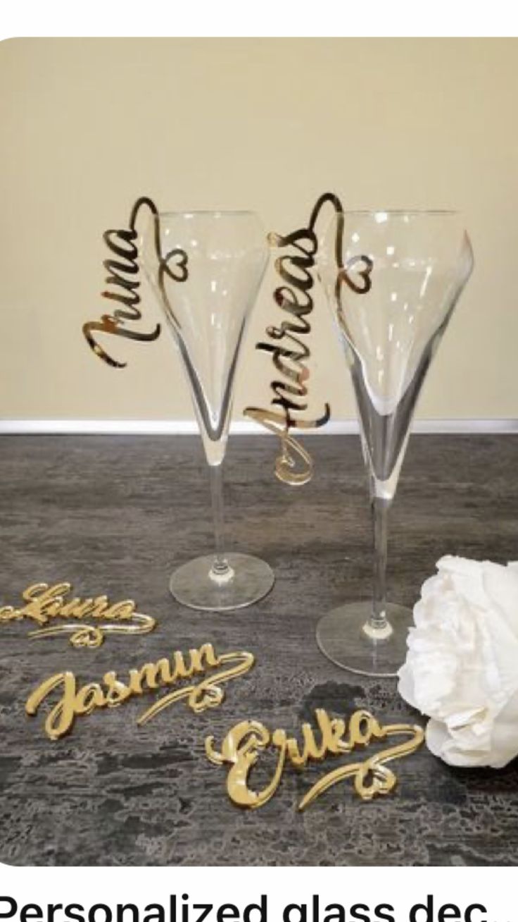 three wine glasses sitting on top of a table next to each other with name written on them