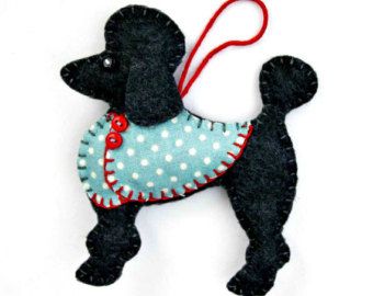 a black poodle ornament hanging from a red string