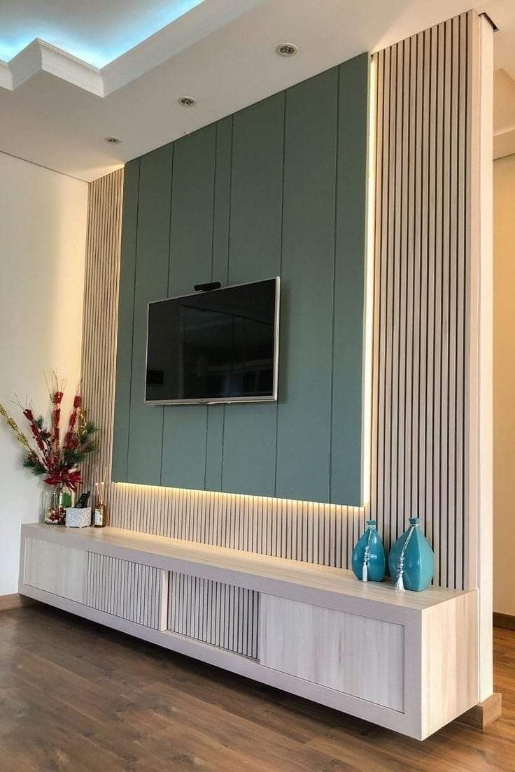 a living room with a flat screen tv mounted on the wall and wooden flooring