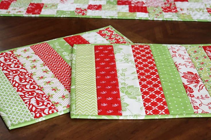 three quilted placemats sitting on top of a wooden table next to each other