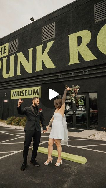 a man and woman are dancing in front of the punk rock museum on their wedding day