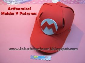 a red hat with an m on it sitting on top of a pink tablecloth