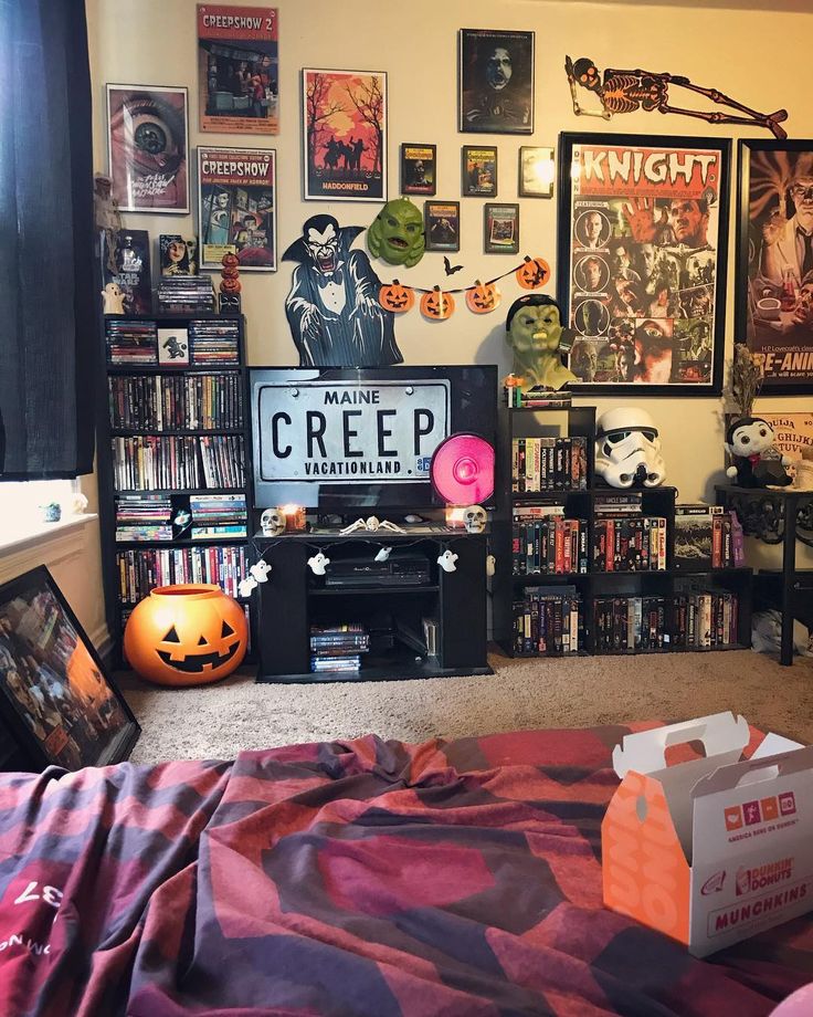 a room filled with lots of halloween decorations and movies on the wall, including bookshelves