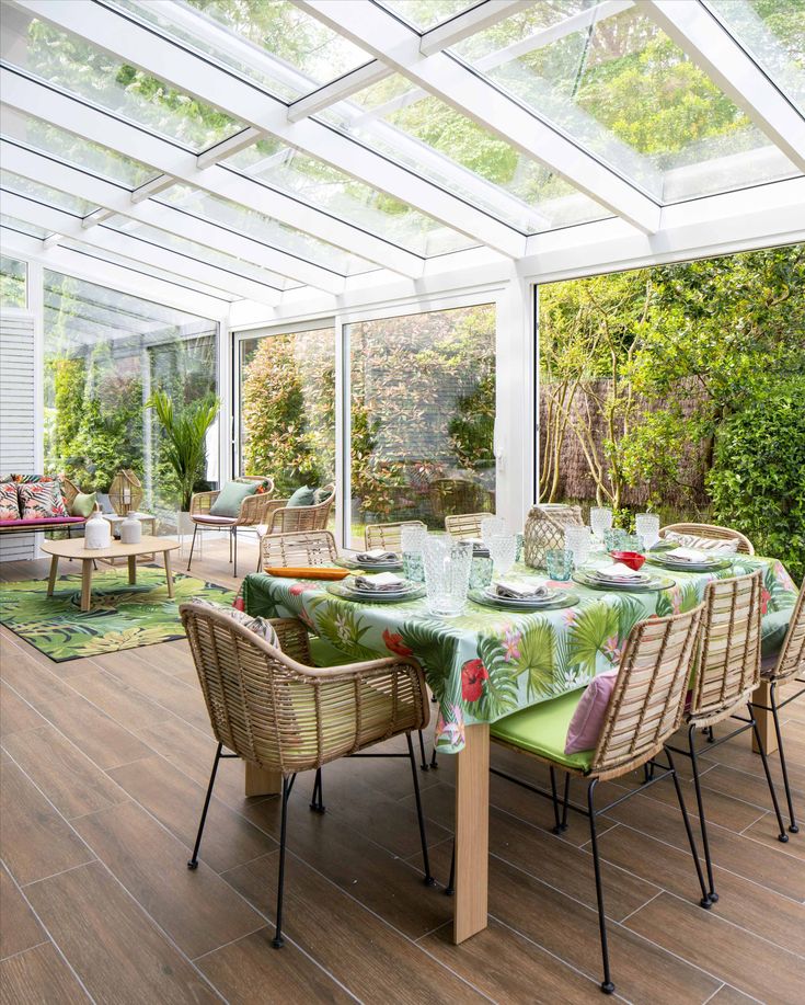 a dining room table set with place settings and chairs for eight people, in front of an enclosed patio area