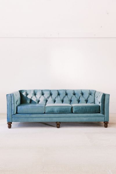 a blue couch sitting on top of a white floor