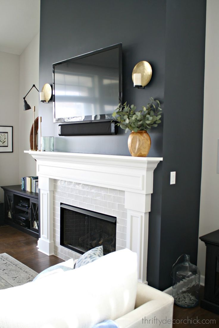 a living room filled with furniture and a flat screen tv mounted on the wall above a fireplace