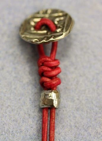 a red cord with a metal clasp on it