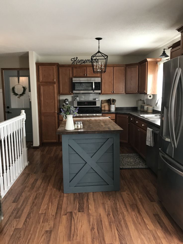 a kitchen with wood flooring and an island in front of the stove top oven