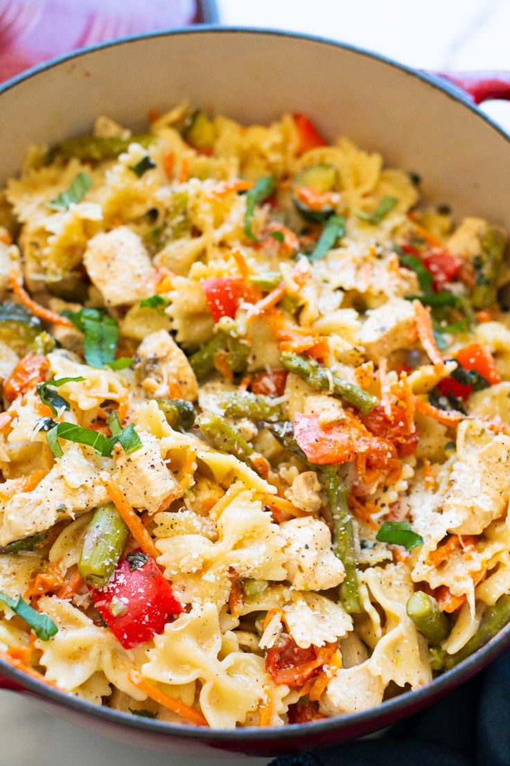 a pot filled with pasta and vegetables on top of a table