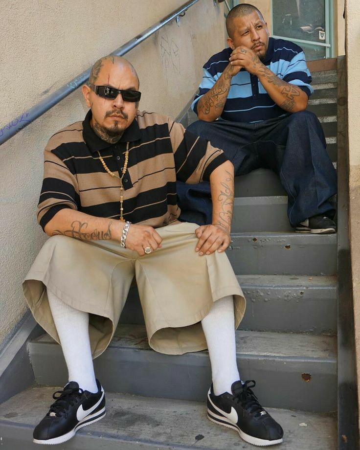 two men sitting on the steps with their arms crossed and one man wearing sunglasses is holding his hand up to his mouth